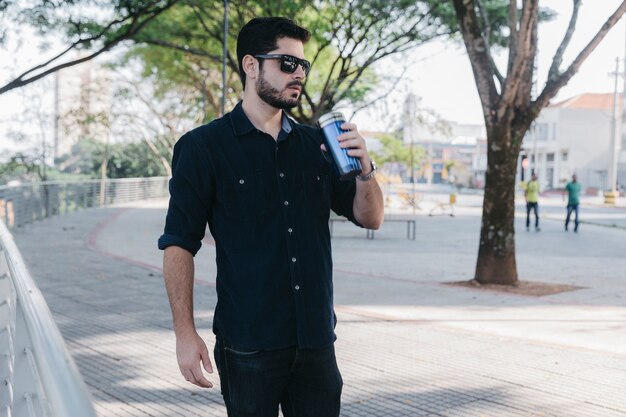 Man in sunglasses with thermocup