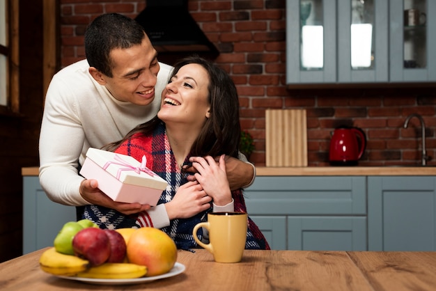 Man surprising woman with a present