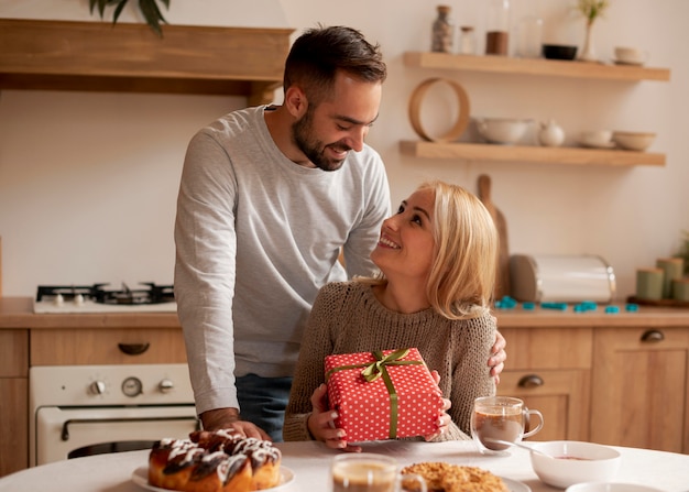 Man surprising woman with present