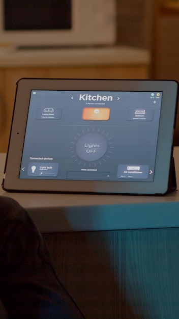 Man switching on bulbs using voice command on tablet