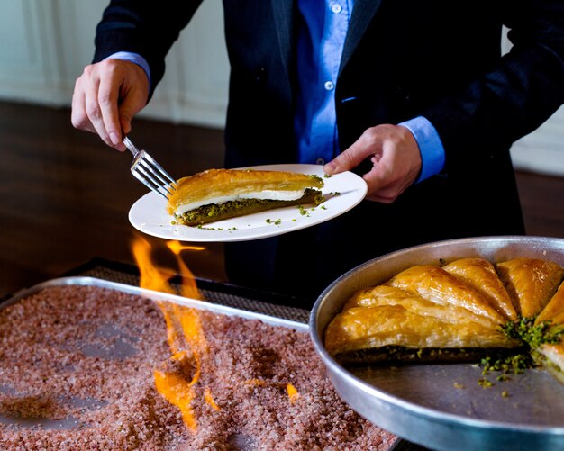 Man takes puff pastry with pistachios