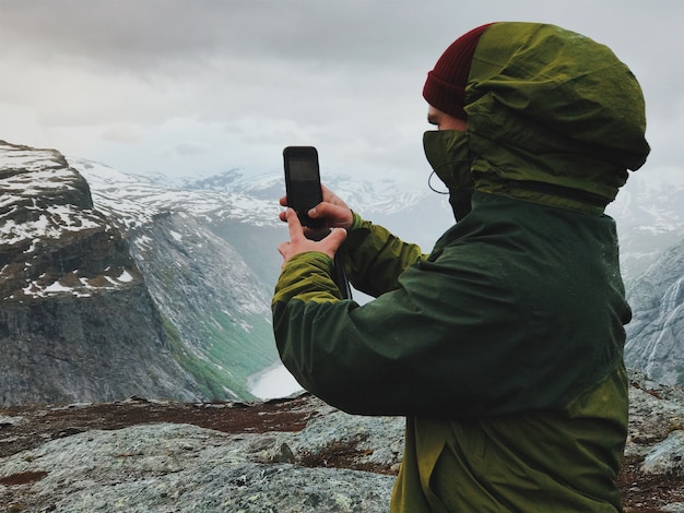 Man takes a selfie in the front of the mountains