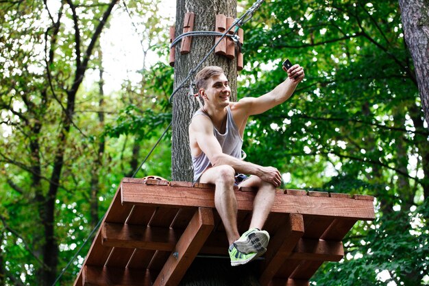 Man takes selfie sitting on the tree