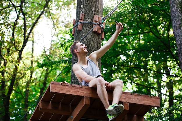 Man takes selfie sitting on the tree