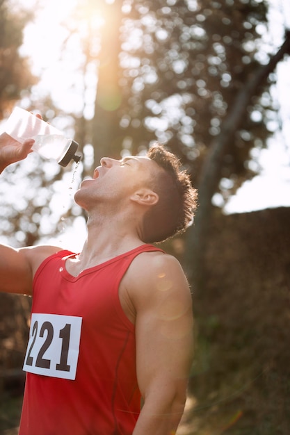 水を飲むために走るのを休んでいる男