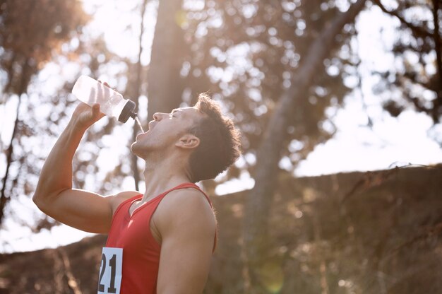 水を飲むために走るのを休んでいる男