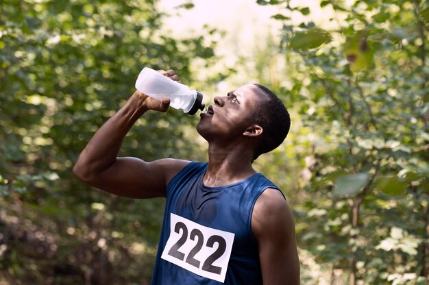 물을 마시기 위해 달리기에서 휴식을 취하는 남자