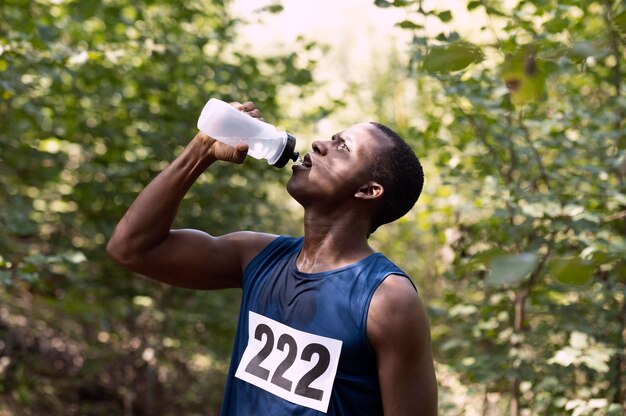 Man taking a break from running to drink water