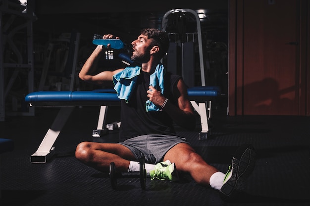 Free photo man taking a break in gym