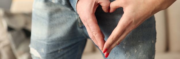 Man taking his hand out of fly and holding it in shape of heart