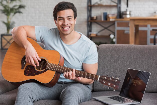 Man taking online courses for playing guitar