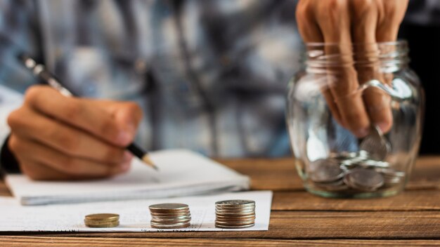 Man taking out coins from saving jar