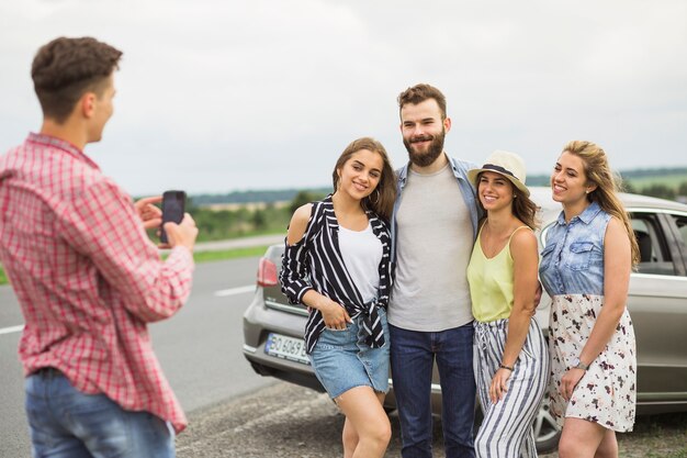 Man taking photo of his friends on road