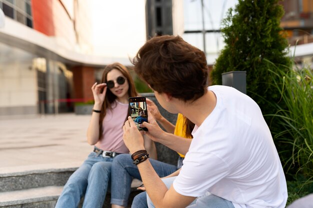 Man taking photo of his friends while outdoors