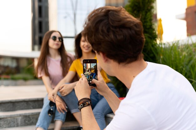 Man taking photo of his friends while outdoors
