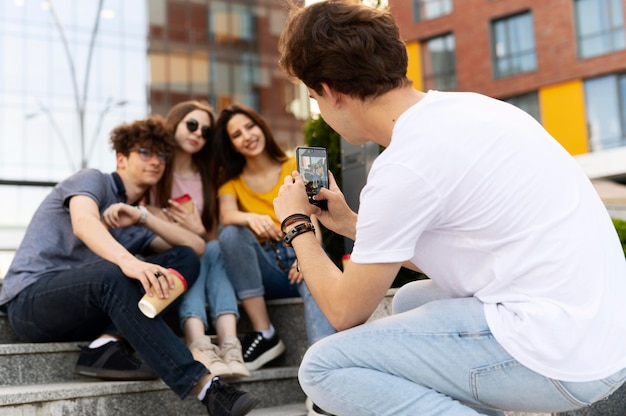 Man taking photo of his friends while outdoors