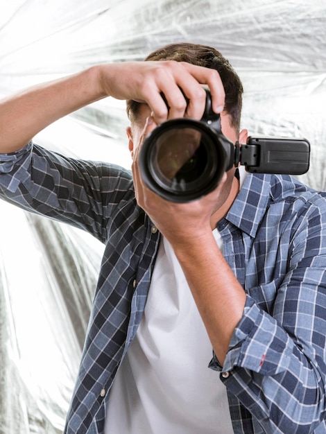 Foto gratuita uomo che scatta una foto con una macchina fotografica professionale