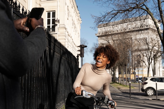 프랑스 도시에서 자전거를 타는 여성의 사진을 찍는 남자