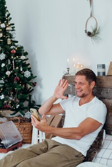 クリスマス​に​モバイル​で​写真​を​撮る​男​が​家​を​飾った​家族​オンライン​おめでとう​ございます