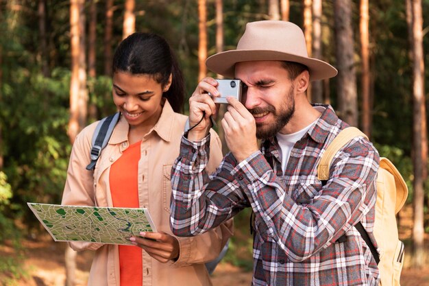 Мужчина фотографирует, пока его девушка проверяет карту