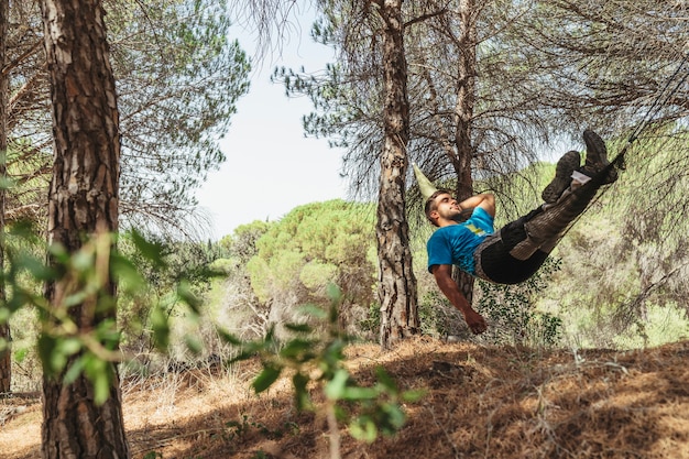 Man taking a rest in hammock in forest