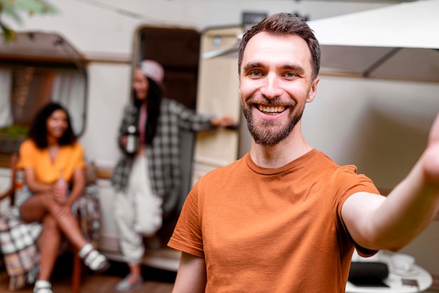 Uomo che prende un selfie e donne sfocate