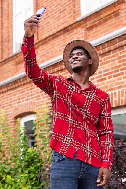 Free photo man taking a selfie while standing