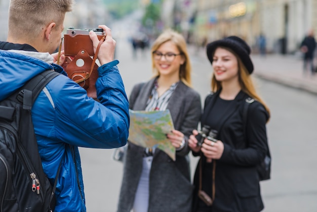 Free photo man taking shot of tourists