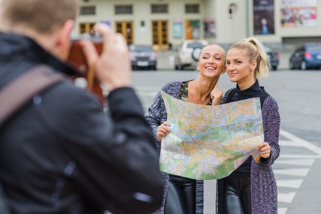 Man taking shot of young pretty tourists