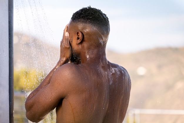 Man taking shower portrait side view