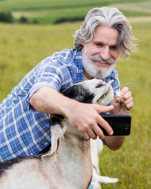 Man taking slefie with goat