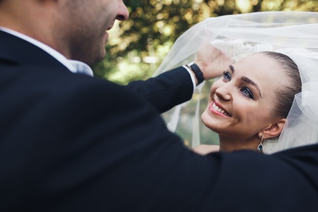 Man taking veil off bride