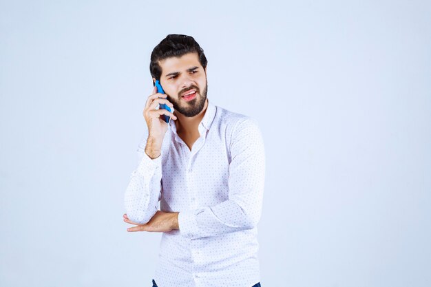 Man talking to his blue new model smartphone