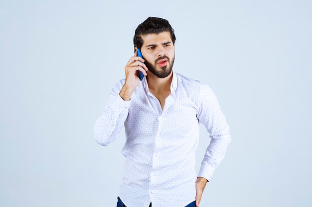 Man talking to his blue new model smartphone