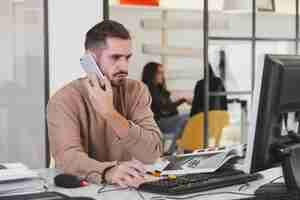 Free photo man talking on phone in office