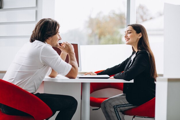 Man talking with female sales person in a car show room