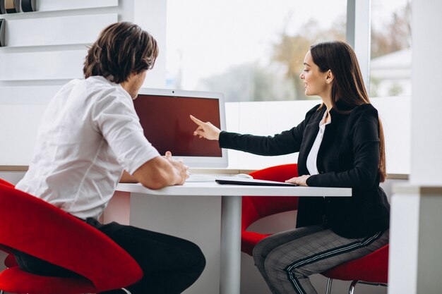 Man talking with female sales person in a car show room