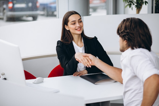 Free photo man talking with female sales person in a car show room