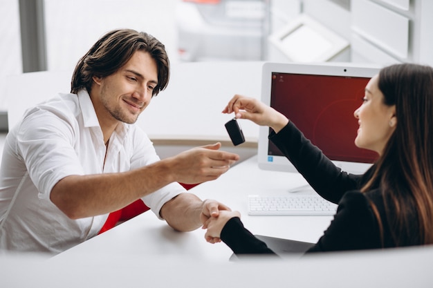 Man talking with female sales person in a car show room