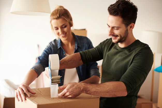 Man taping cardboard box to move