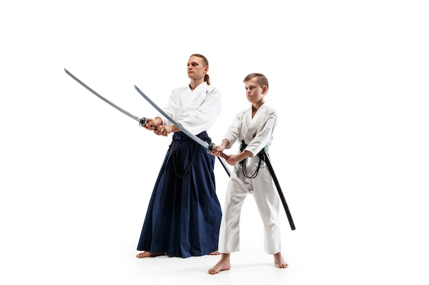 Мужчина и мальчик-подросток борются на тренировках по айкидо в школе боевых искусств. Концепция здорового образа жизни и спорта.