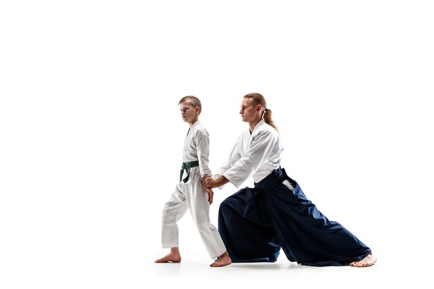 Мужчина и мальчик-подросток борются на тренировках по айкидо в школе боевых искусств