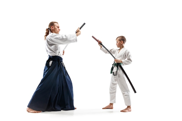 Free photo man and teen boy fighting at aikido training in martial arts school