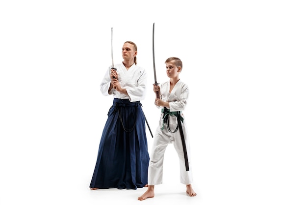 Uomo e ragazzo adolescente che combattono all'addestramento di aikido nella scuola di arti marziali