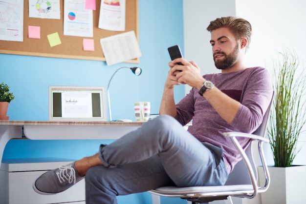 彼の携帯電話でテキストメッセージを送る男