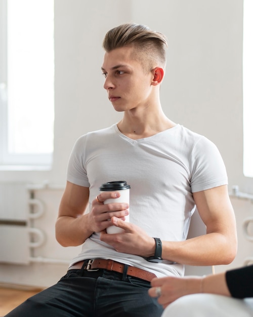 Foto gratuita uomo in terapia tenendo la tazza di caffè