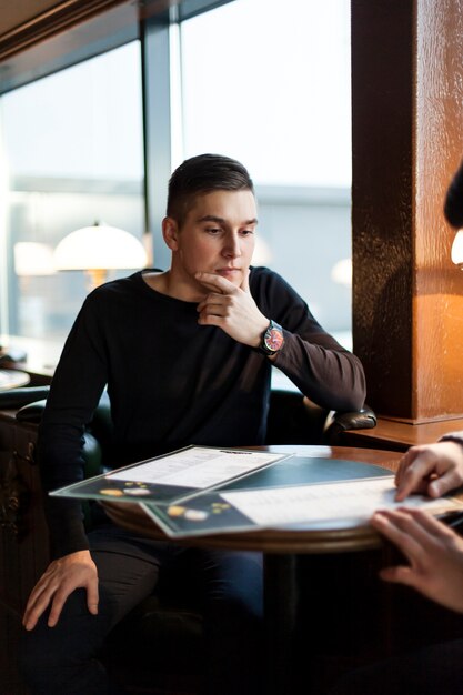Man thinking over order in cafe