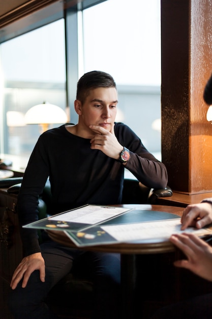 Man thinking over order in cafe
