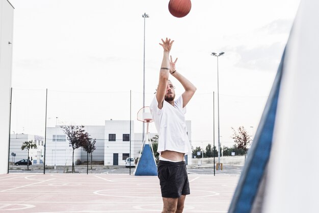 空中でバスケットボールを投げる男
