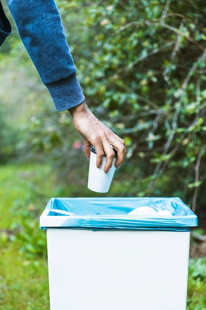 Man throwing up garbage in bin 